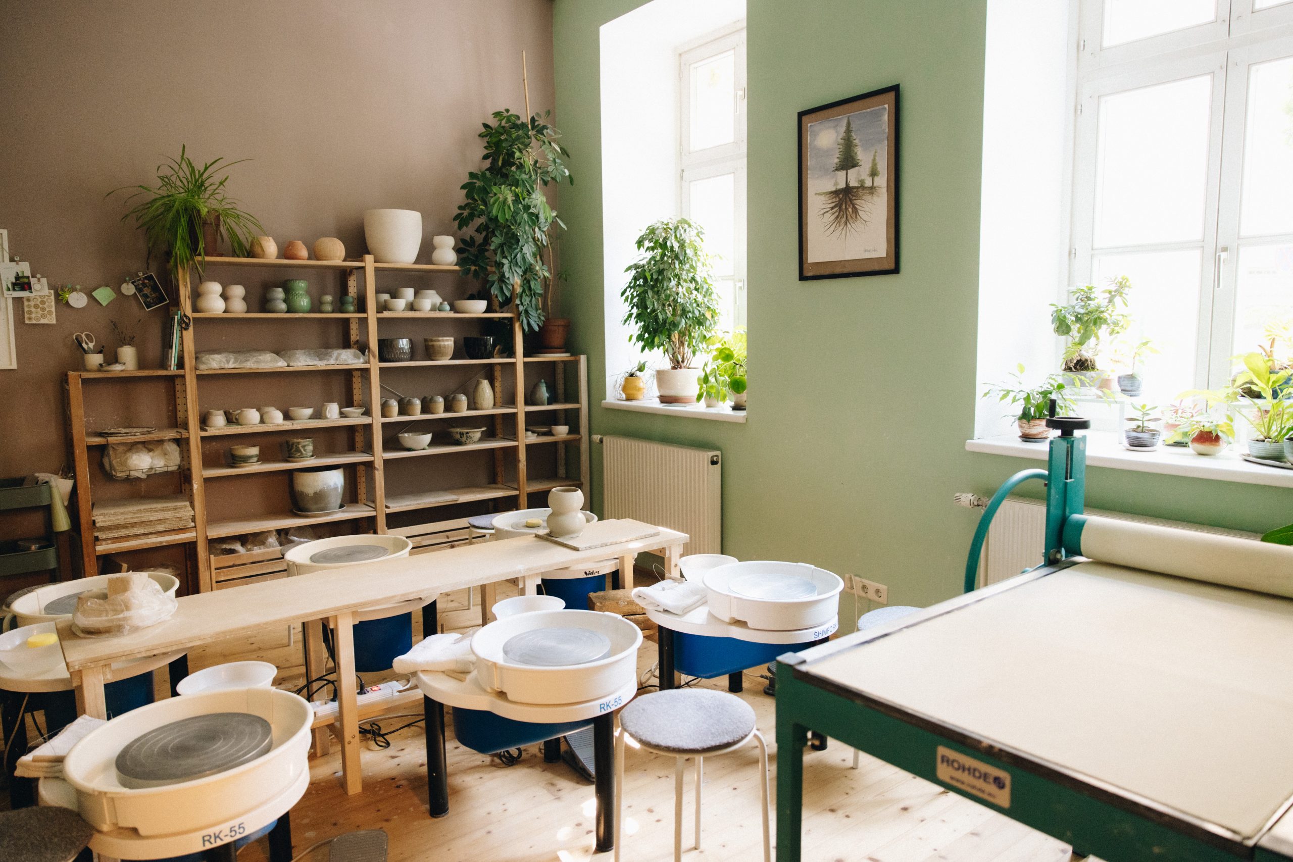 Atmosphäre im Verenics Töpferstudio Wien - heller Kursraum mit Töpferscheiben, Regalen voller Keramikwerke und entspannter Stimmung.