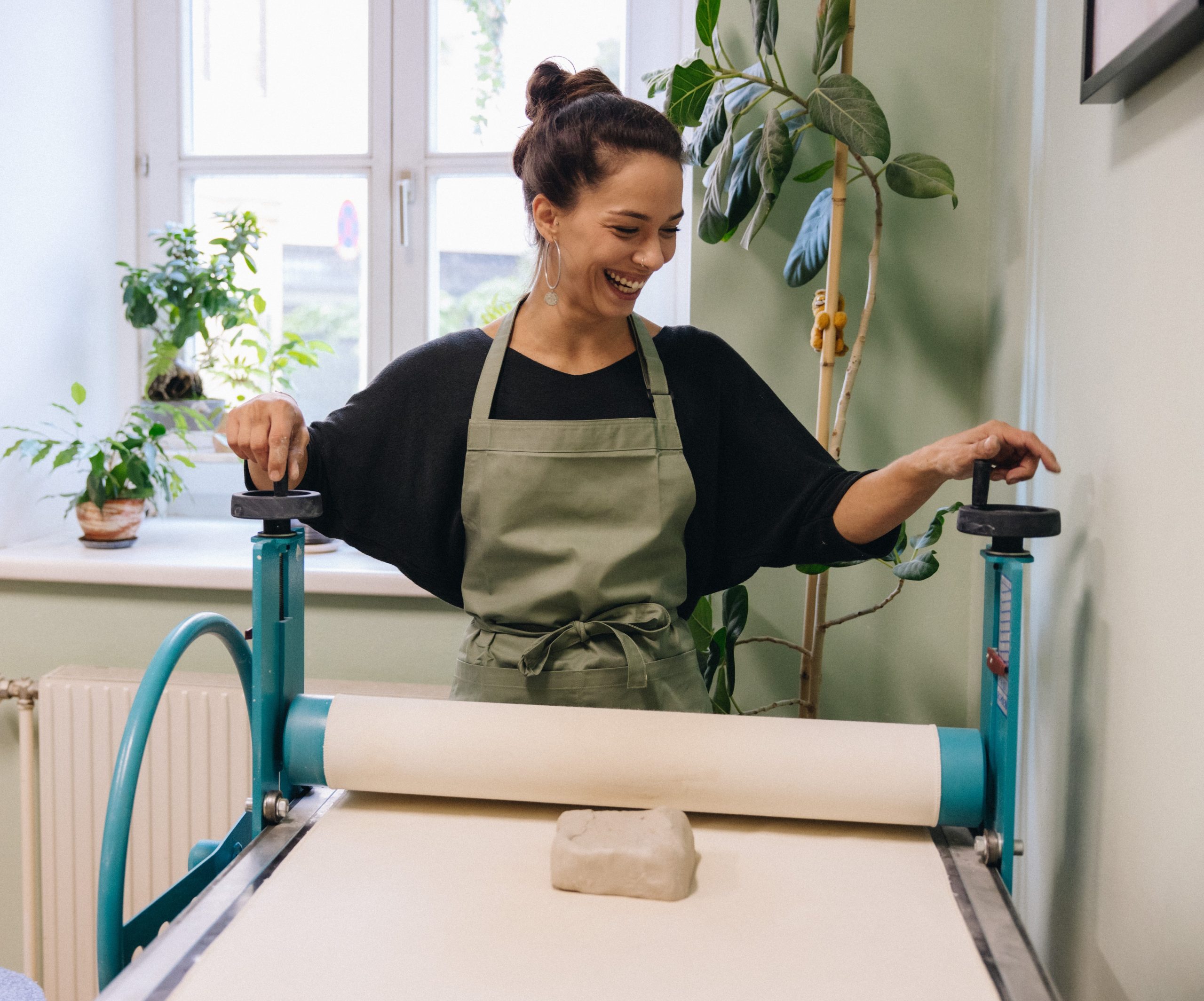 Verena bei der Arbeit an der Plattenwalze im Verenics Keramikstudio Wien - Ton vorbereiten für kreative Töpferkurse.