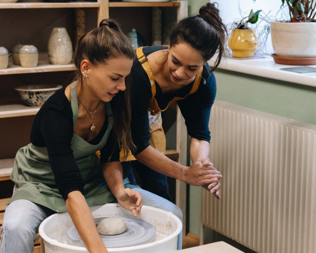 Verena begleitet Valentina an der Töpferscheibe - Freude am Ausprobieren, ohne Druck - Erfahrung im kreativen Prozess.